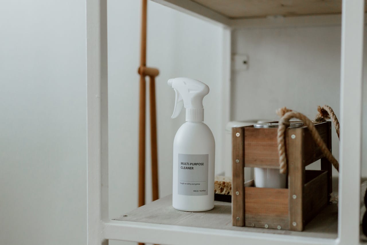 services-04 Clean white shelf with a spray cleaner and wooden caddy, perfect for home organization.